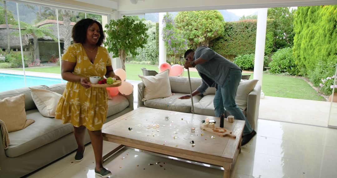 Couple Tidying Up After Party at Home, Embracing Teamwork