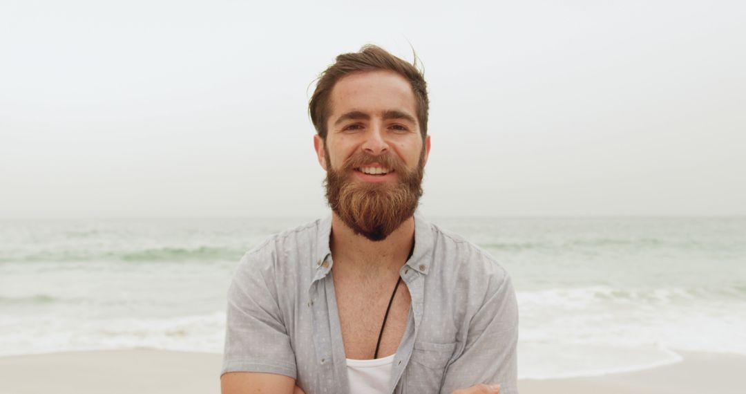 Relaxed Young Man Smiling on Beach with Sectored Hair and Beard