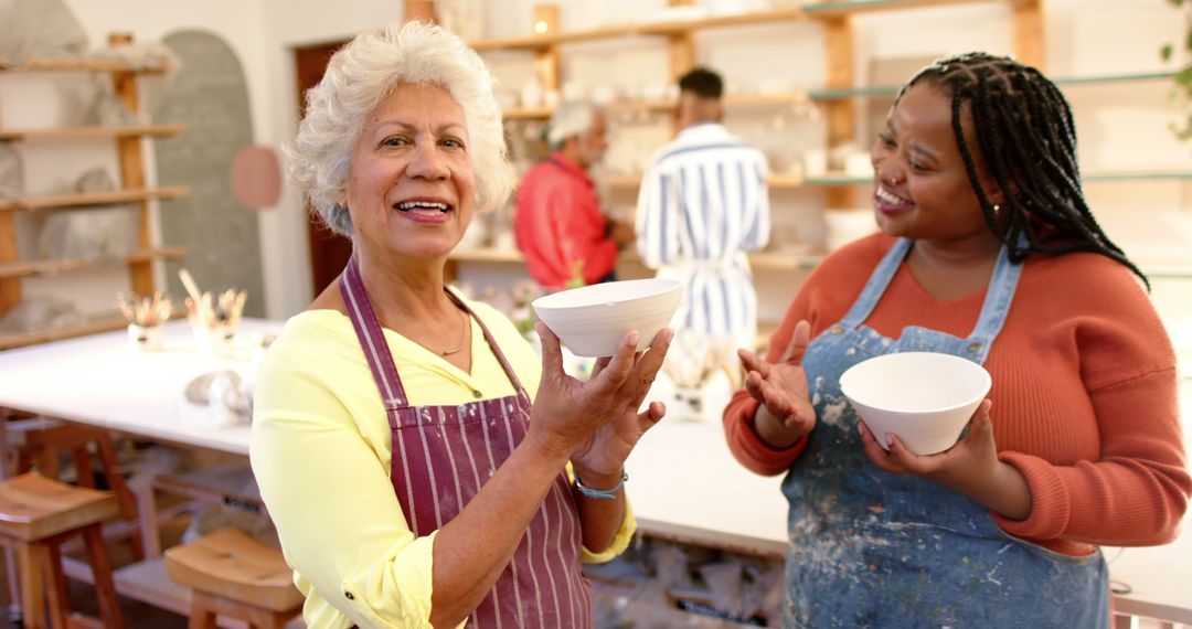 Happy Senior Woman and Younger Woman Holding Pottery in Art Studio - Free Images, Stock Photos and Pictures on Pikwizard.com