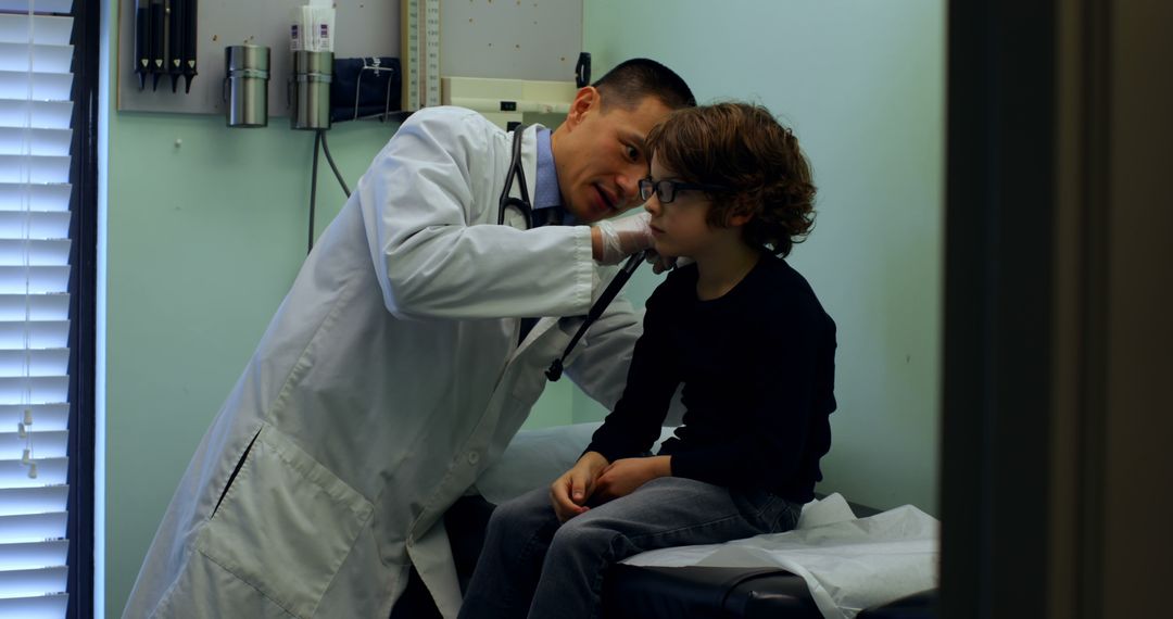 Male Doctor Examining Young Boy's Ear in Medical Clinic - Free Images, Stock Photos and Pictures on Pikwizard.com