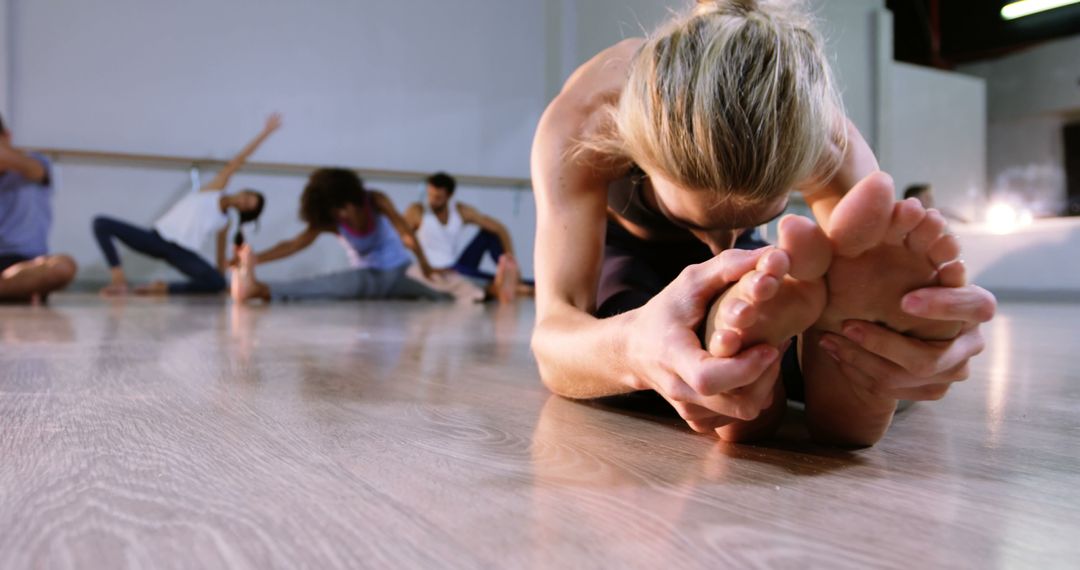 Group Practicing Yoga Stretches on Wooden Floor in Bright Studio - Free Images, Stock Photos and Pictures on Pikwizard.com