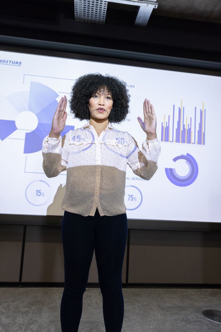 Businesswoman Presenting Statistical Data on Projection Screen