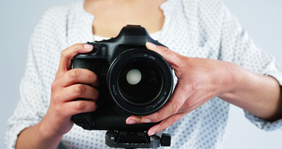 Female Photographer Holding DSLR Camera in Professional Studio - Free Images, Stock Photos and Pictures on Pikwizard.com