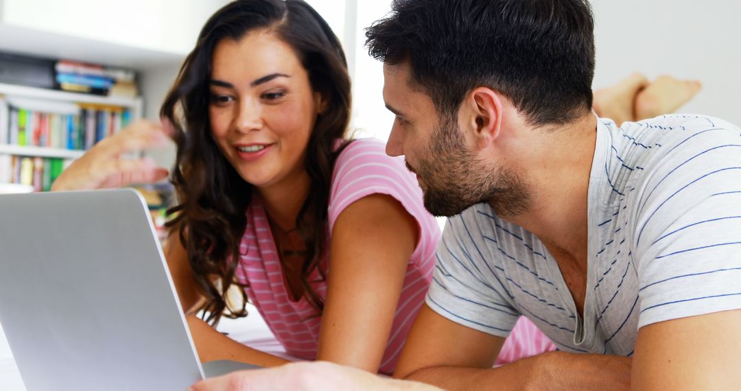 Young Couple Smiling While Using Laptop in Bedroom - Free Images, Stock Photos and Pictures on Pikwizard.com