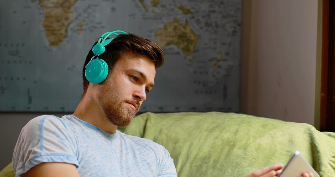 Young Man Relaxing on Couch with Headphones and Smartphone - Free Images, Stock Photos and Pictures on Pikwizard.com