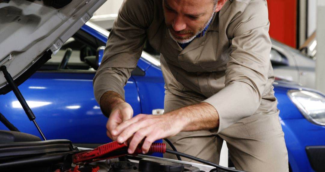 Auto Mechanic Jumpstarting Car Battery in Repair Shop - Free Images, Stock Photos and Pictures on Pikwizard.com