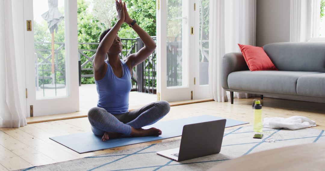 Woman doing yoga at home with laptop guidance in serene living room - Free Images, Stock Photos and Pictures on Pikwizard.com