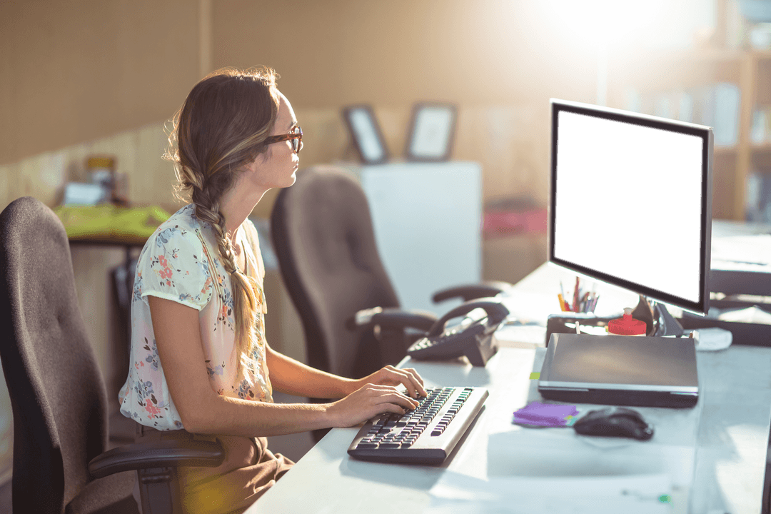 Woman Sitting at Desk Working on Computer with Transparent Screen