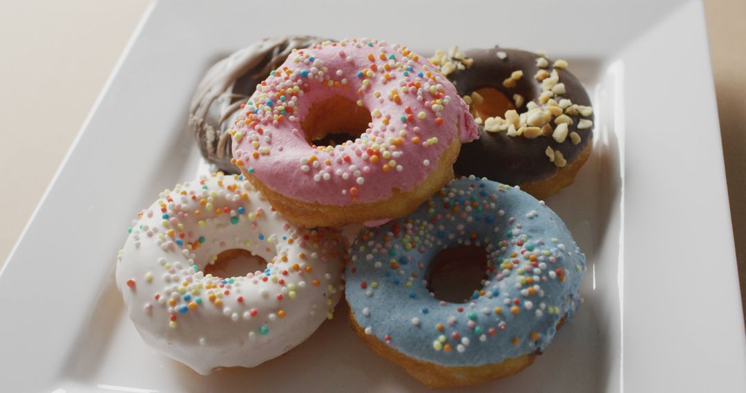 Assorted Donuts with Colorful Icing and Sprinkles on White Plate - Free Images, Stock Photos and Pictures on Pikwizard.com