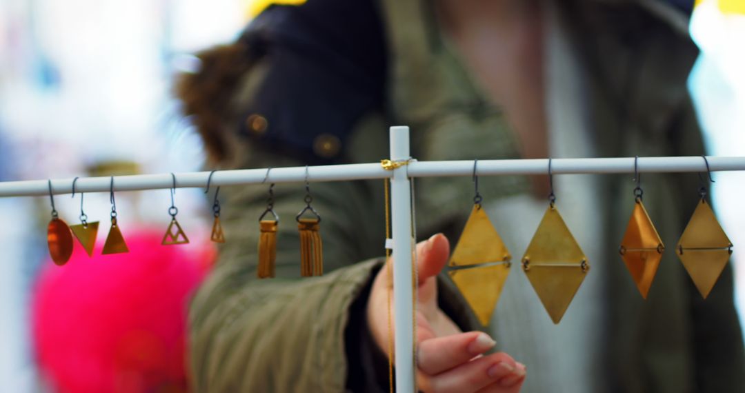 Person Browsing Handmade Geometric Earrings at Outdoor Market - Free Images, Stock Photos and Pictures on Pikwizard.com