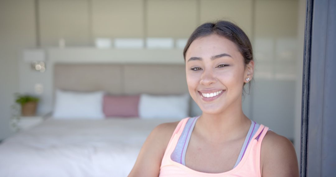 Smiling Woman Relaxing in Bedroom, Showing Ease and Happiness