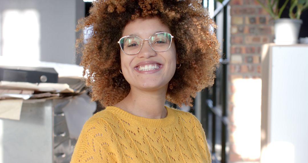 Smiling Woman with Curly Hair Wearing Glasses in Office - Free Images, Stock Photos and Pictures on Pikwizard.com