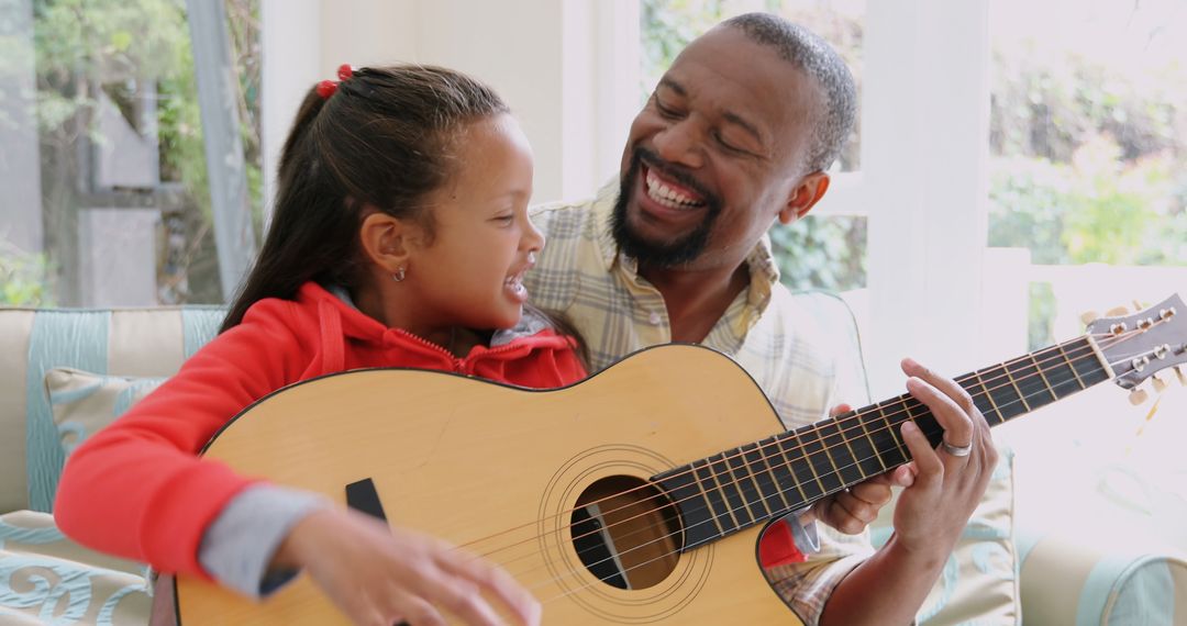 Father and Daughter Playing Guitar Together at Home, Smiling and Enjoying Music - Free Images, Stock Photos and Pictures on Pikwizard.com