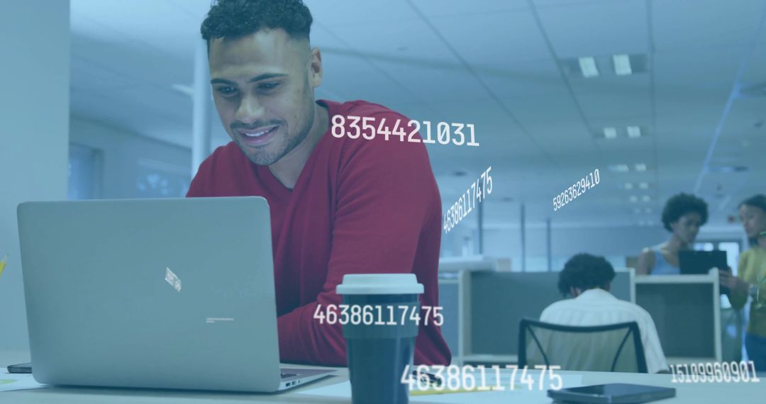 Focused Man Working on Laptop with Data Holograms in Office