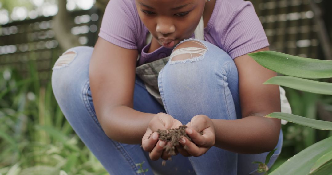 Girl examining soil in garden - Free Images, Stock Photos and Pictures on Pikwizard.com