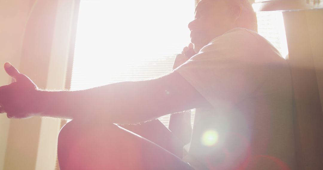 Silhouette of Man Talking on Phone with Sunlight Streaming Through Window - Free Images, Stock Photos and Pictures on Pikwizard.com