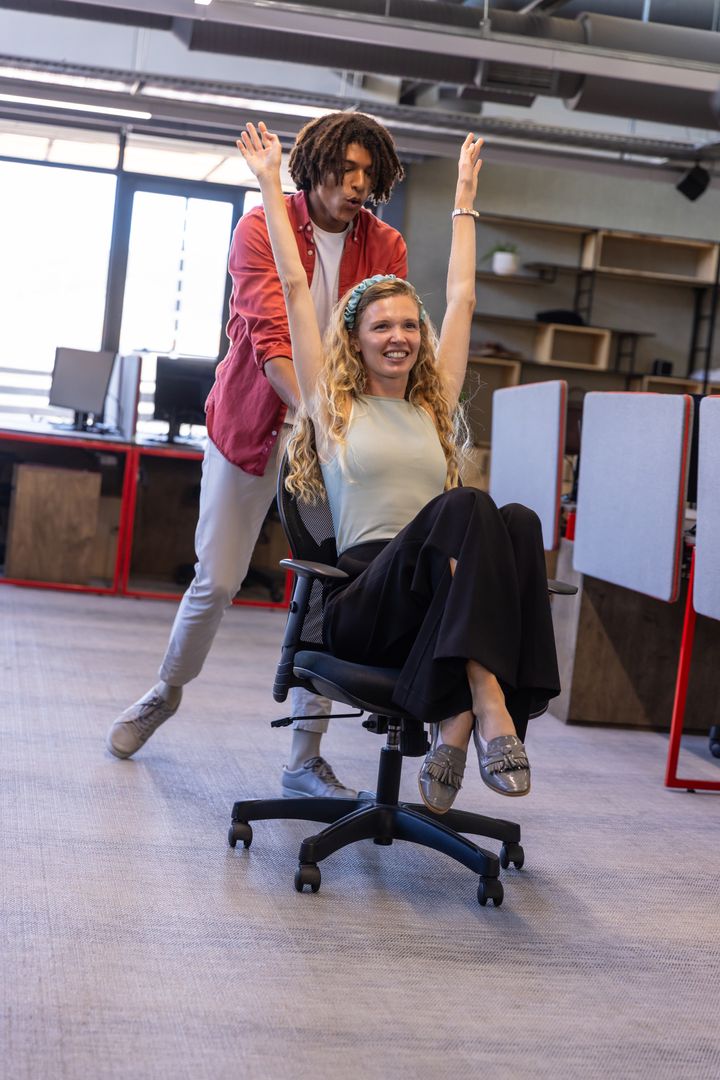 Diverse Coworkers Laughing in Dynamic Office Environment