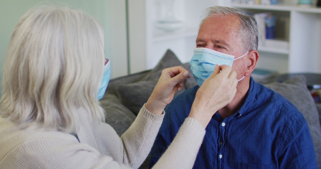 Senior Couple Adjusting Face Masks on Sofa