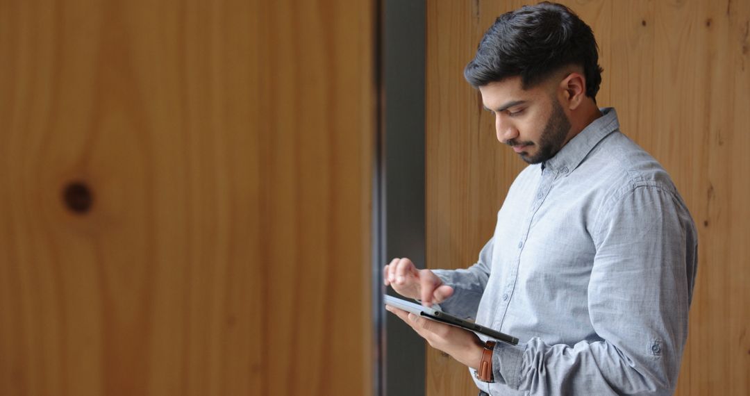 Young Professional Using Tablet in Modern Corridor