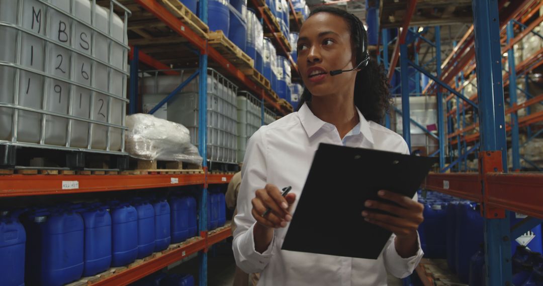 Warehouse Manager Coordinating Inventory Using Headset and Clipboard - Free Images, Stock Photos and Pictures on Pikwizard.com