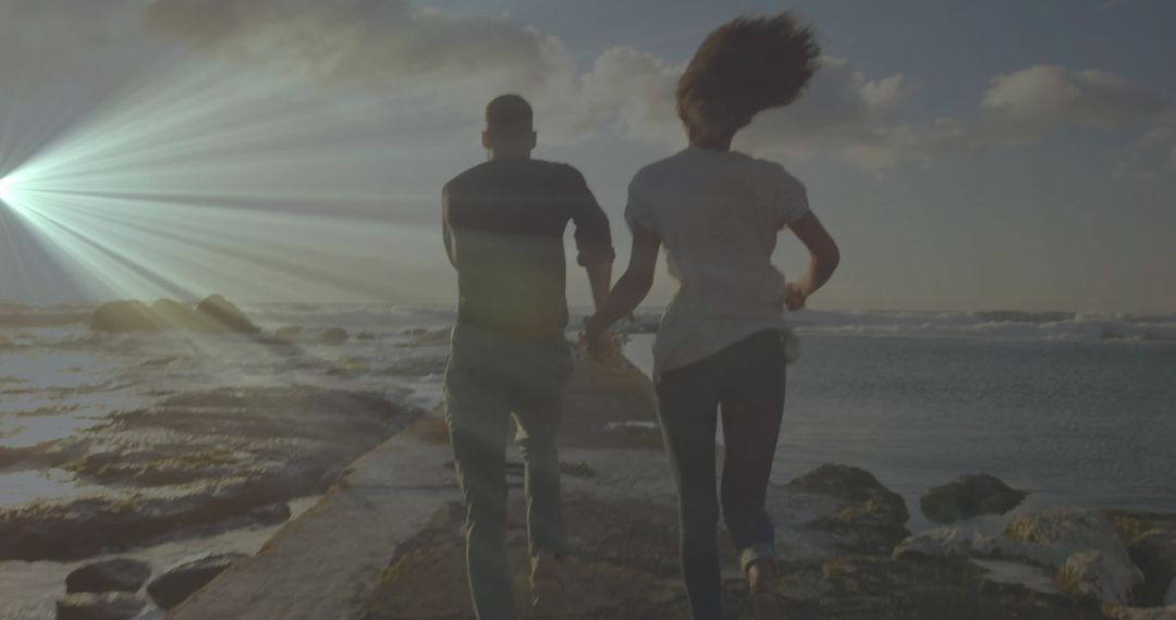 Couple Running on Jetty at Sunset in Scenic Beach Atmosphere