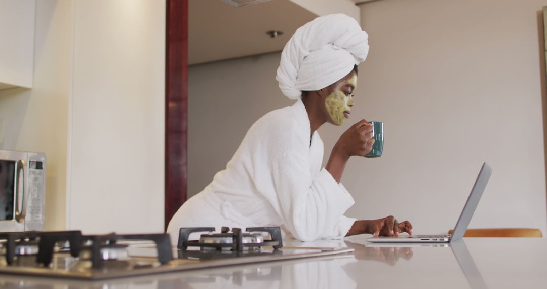 An African American woman enjoys a home spa day with a face mask, coffee, and laptop use. - Free Images, Stock Photos and Pictures on Pikwizard.com