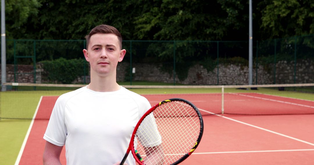 Young Man Holding Tennis Racket on Outdoor Court - Free Images, Stock Photos and Pictures on Pikwizard.com