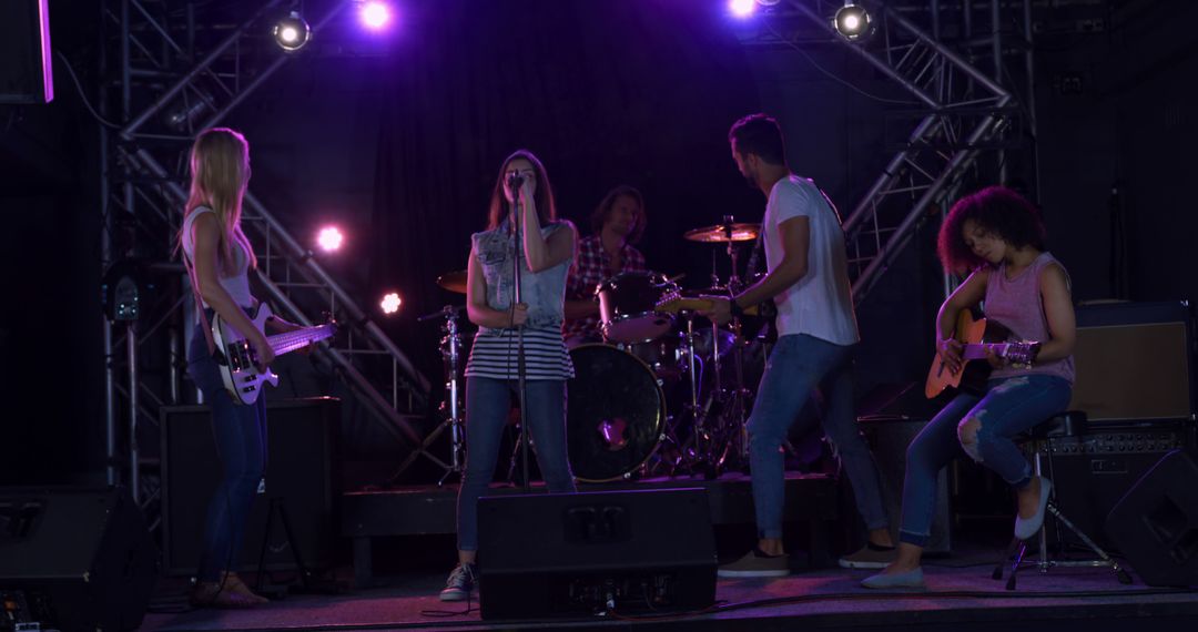 Diverse Rock Band Rehearsing on Stage During Evening