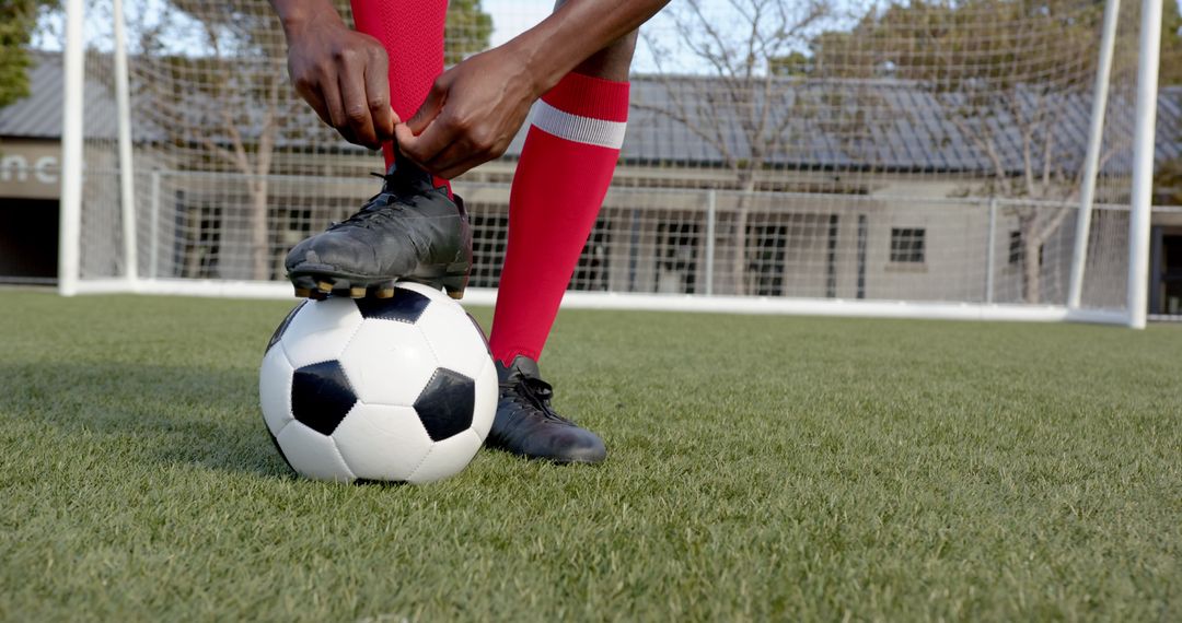 Soccer Player Tying Cleats Preparing for Game on Field