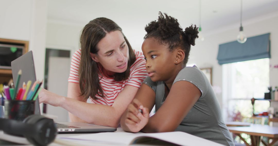 Mother Assisting Daughter with Homework Using Laptop
