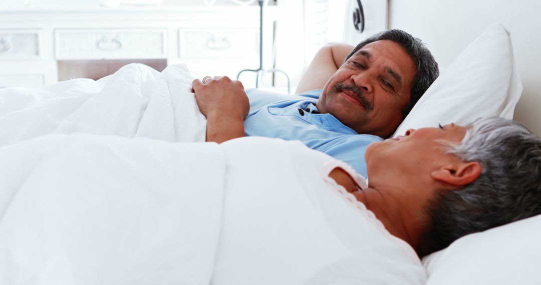 Senior Couple Relaxing in Bed Smiling At Each Other - Free Images, Stock Photos and Pictures on Pikwizard.com