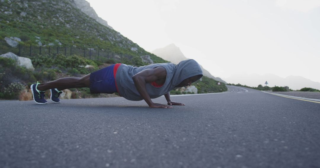 Athletic Man Doing Push-Ups on Mountain Road During Morning Workout - Free Images, Stock Photos and Pictures on Pikwizard.com