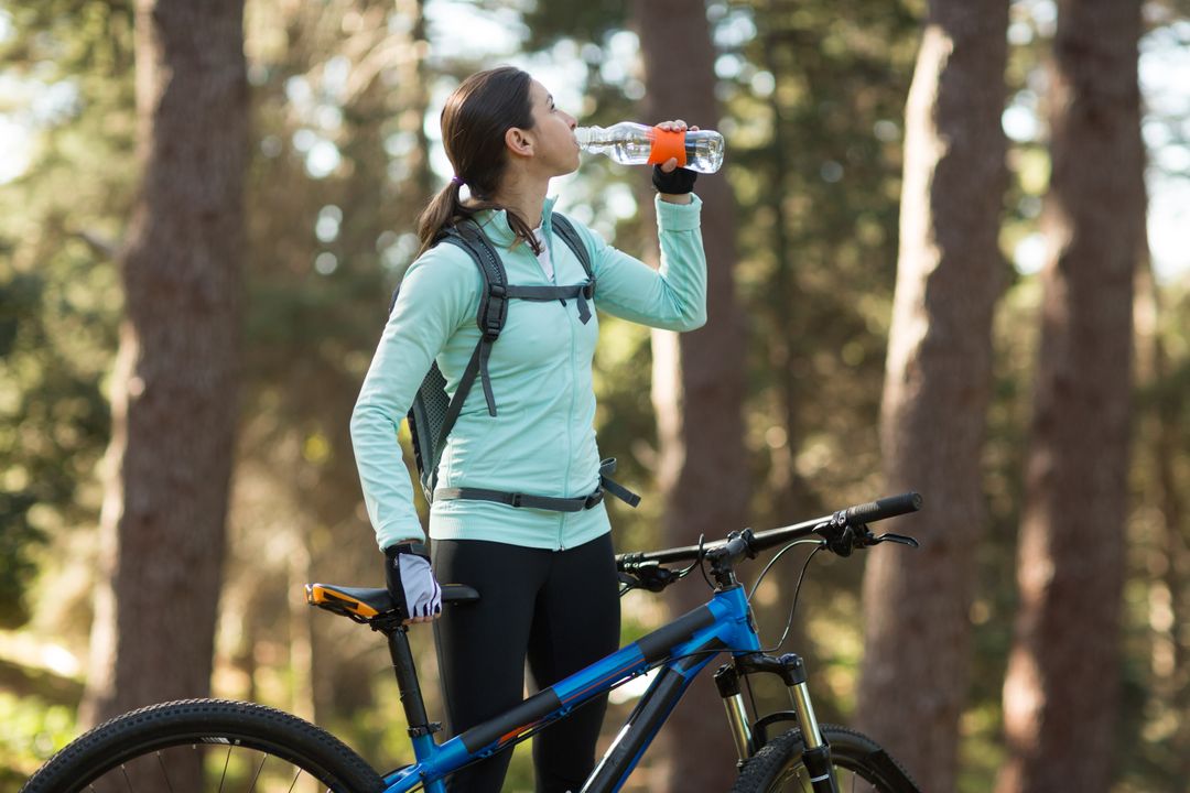 Female Cyclist Hydrating in Forest - Free Images, Stock Photos and Pictures on Pikwizard.com