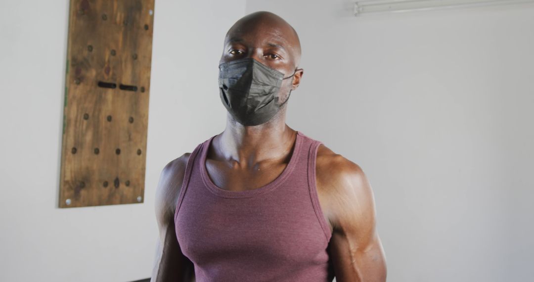 Confident Man in Tank Top Wearing Face Mask Indoors - Free Images, Stock Photos and Pictures on Pikwizard.com