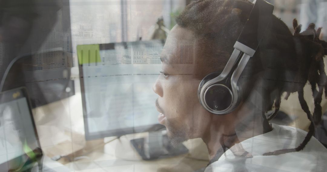 Focused Man Working at Computer with Urban Reflections