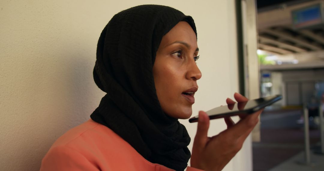 Muslim Woman Using Voice Command on Smartphone at Airport Terminal - Free Images, Stock Photos and Pictures on Pikwizard.com