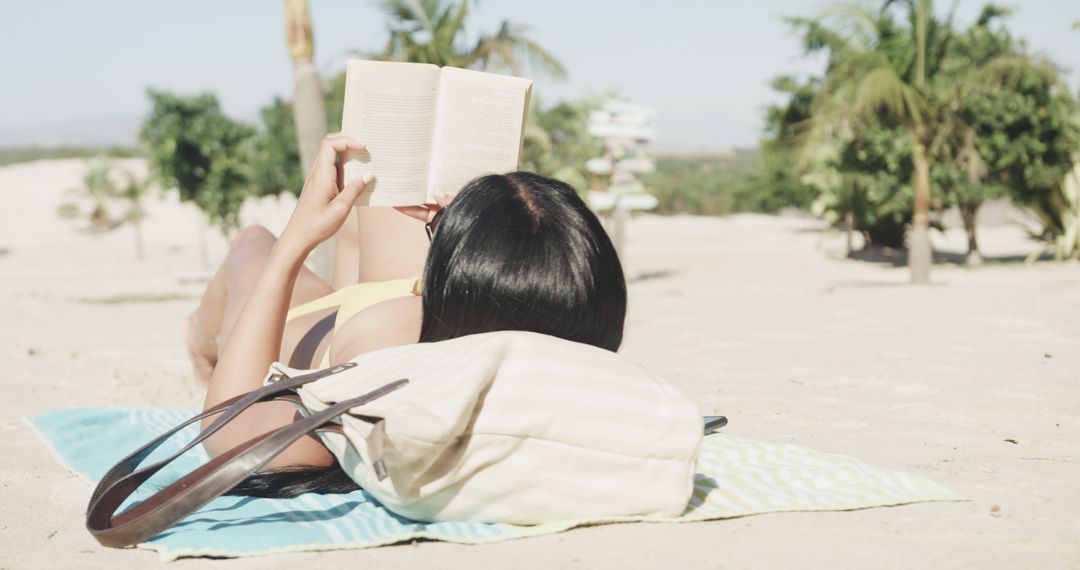 Woman Relaxing on Beach Reading a Book on Sunny Day - Free Images, Stock Photos and Pictures on Pikwizard.com