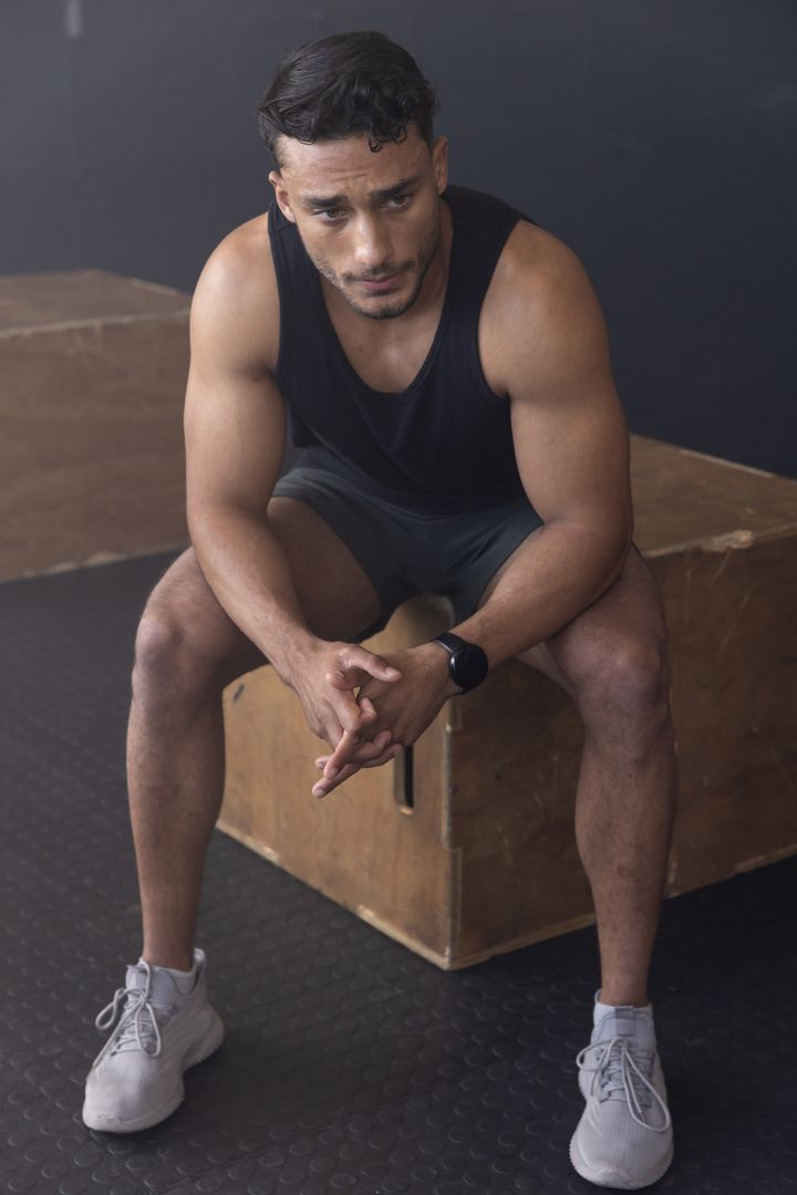 Athlete Resting on Plyometric Box After Workout in Gym