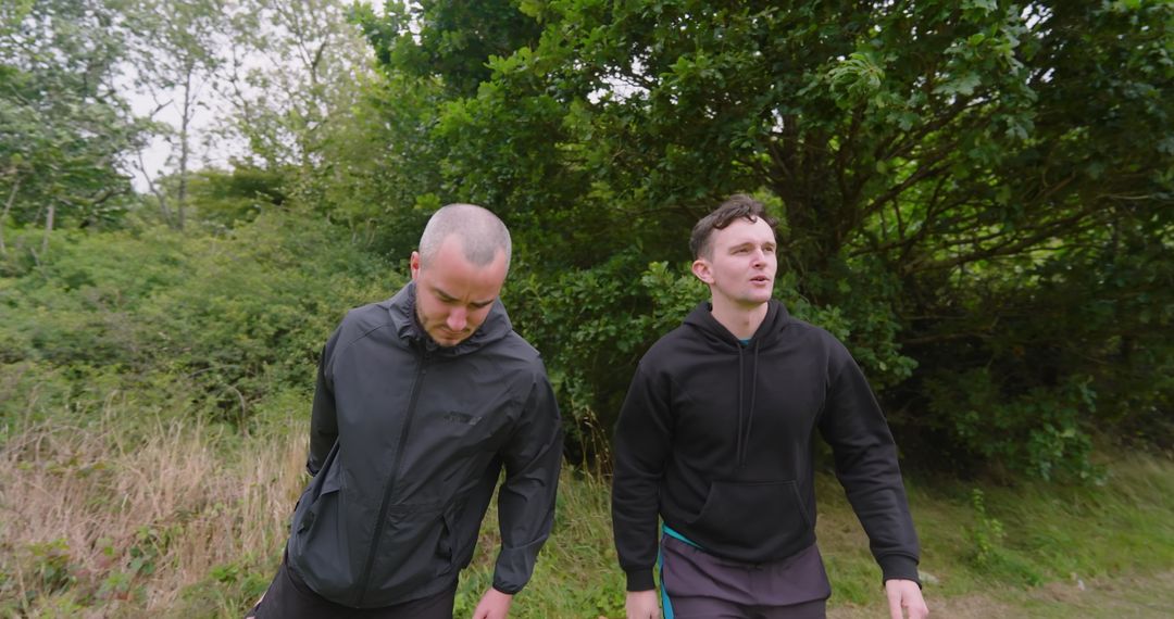 Two Men Enjoying Nature Walk in Lush Green Forest