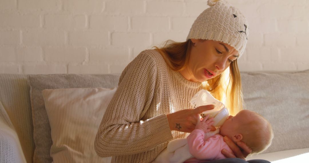 Young Mother Feeding Her Baby with a Bottle in Cozy Home - Free Images, Stock Photos and Pictures on Pikwizard.com