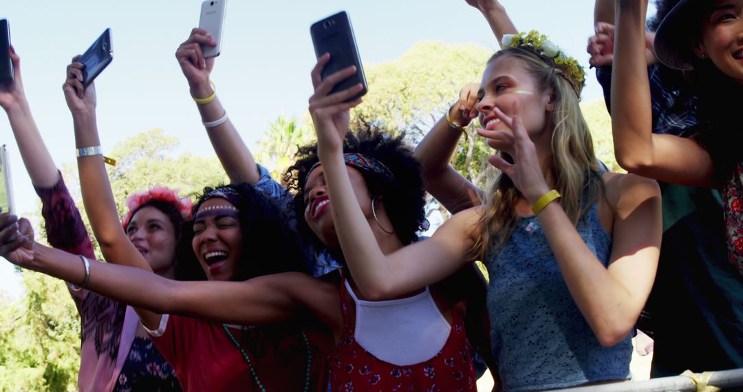 Excited Group of Friends Taking Selfies at Outdoor Festival - Free Images, Stock Photos and Pictures on Pikwizard.com