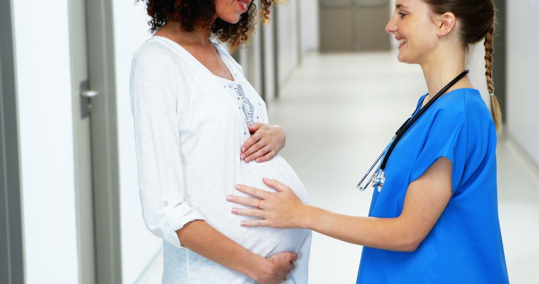 Pregnant Woman Consulting with Nurse in Hospital Hallway - Free Images, Stock Photos and Pictures on Pikwizard.com