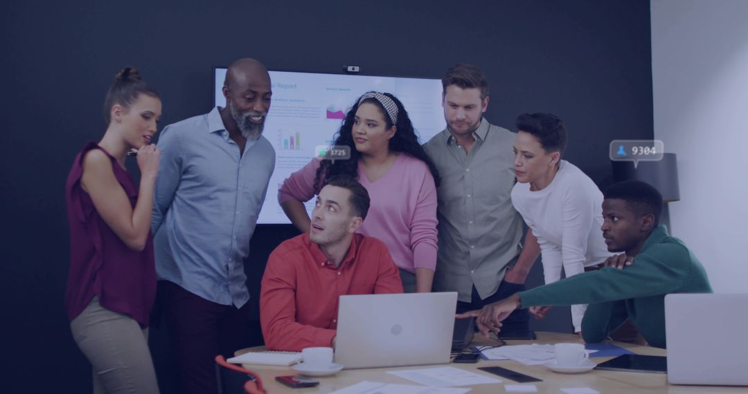 Multicultural Team Collaborating Around Laptop Reviewing Business Charts and Data