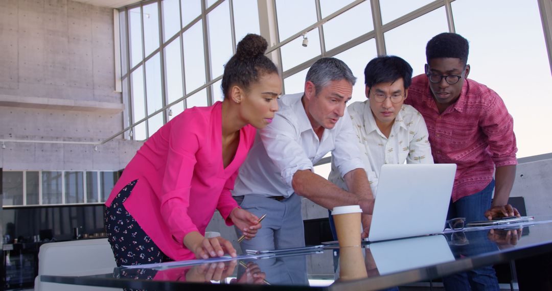 Diverse Team Collaborating at Modern Office Using Laptop