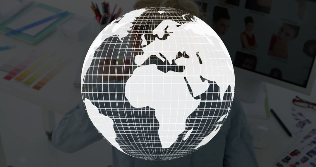 Floating Wireframe Globe Above Designer's Desk Illustrating Global Creativity