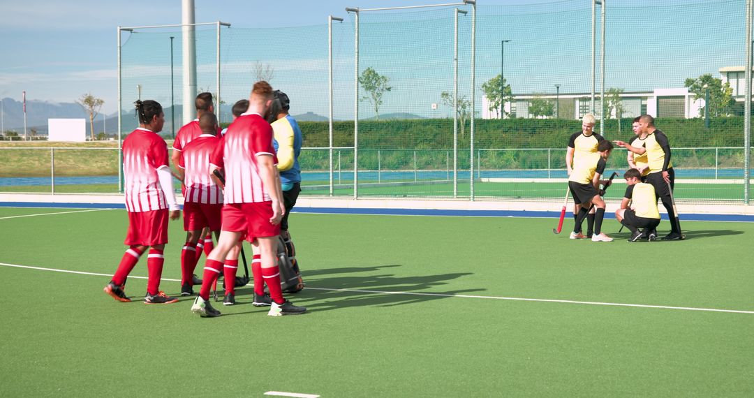 Field Hockey Team Strategizing on Green Turf Field