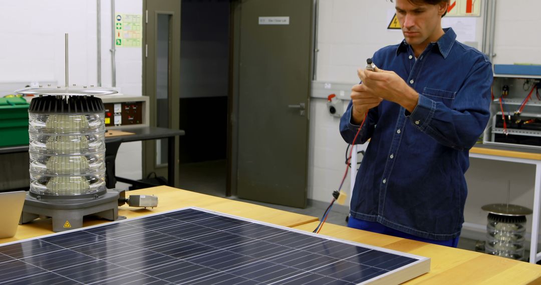 Engineer Working with Solar Panel and LED Beacon in Laboratory - Free Images, Stock Photos and Pictures on Pikwizard.com