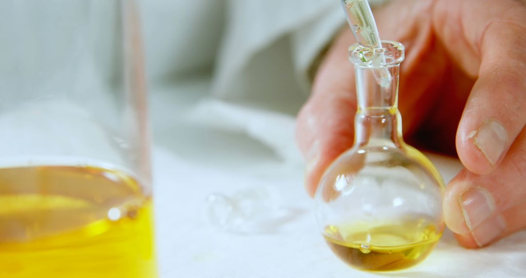 Scientist Pouring Liquid into Laboratory Beaker During Experiment