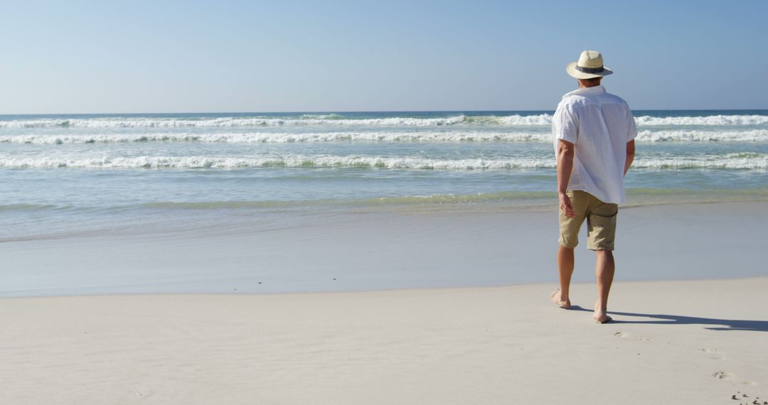 Man Walking on Beach in Casual Summer Attire - Free Images, Stock Photos and Pictures on Pikwizard.com