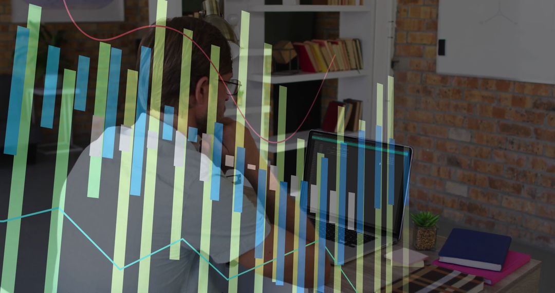 Businessman Analyzing Financial Charts on Laptop in Office